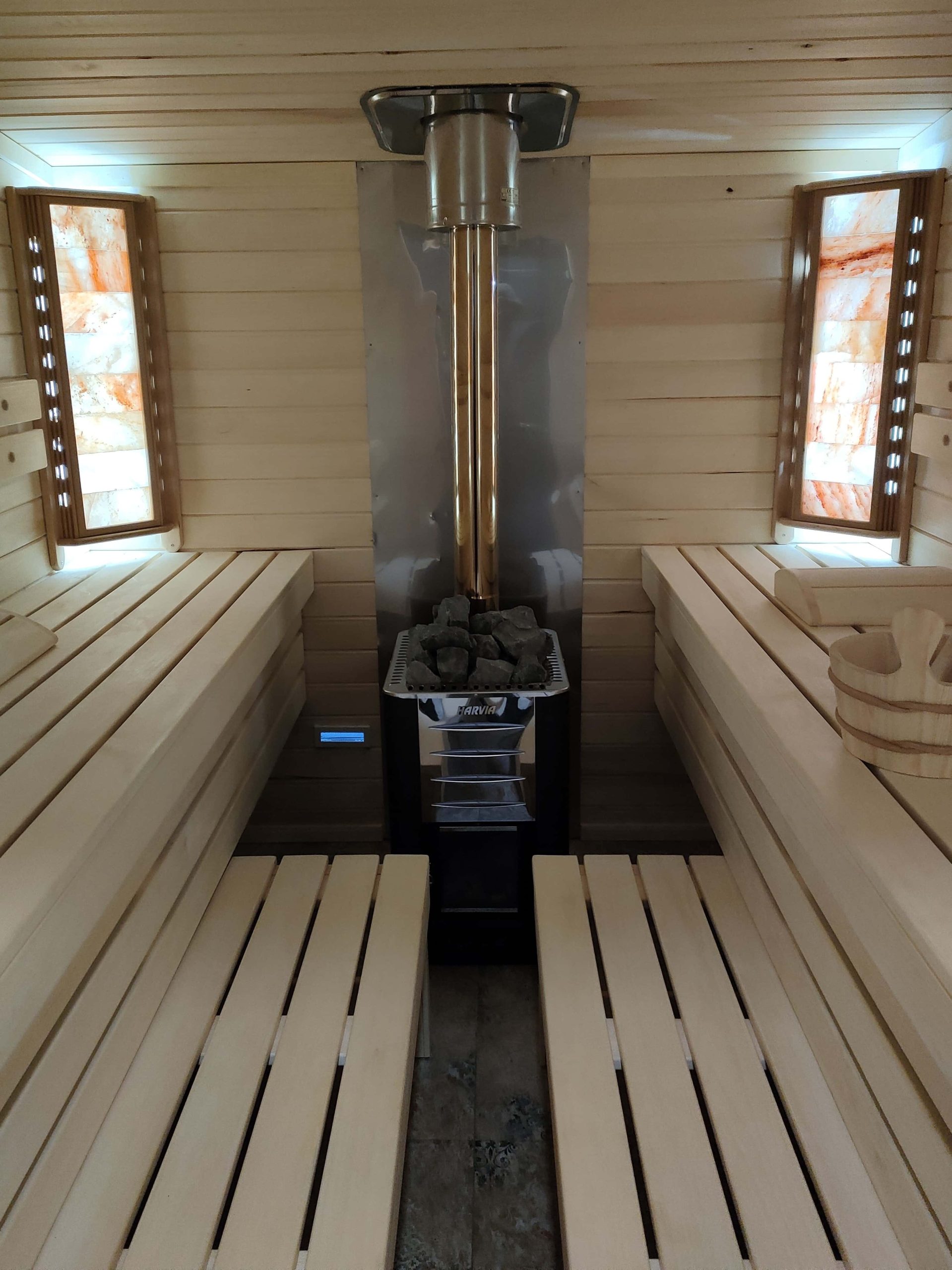 Wnętrze sauny z widokiem na zewnątrz, pokazujące drewniane ławki i relaksującą atmosferę, podkreślającą esencję saunowania.